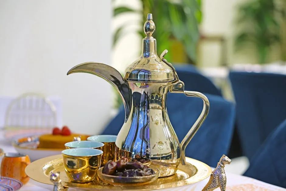 Arabic coffee being poured from a traditional dallah into small cups alongside dates