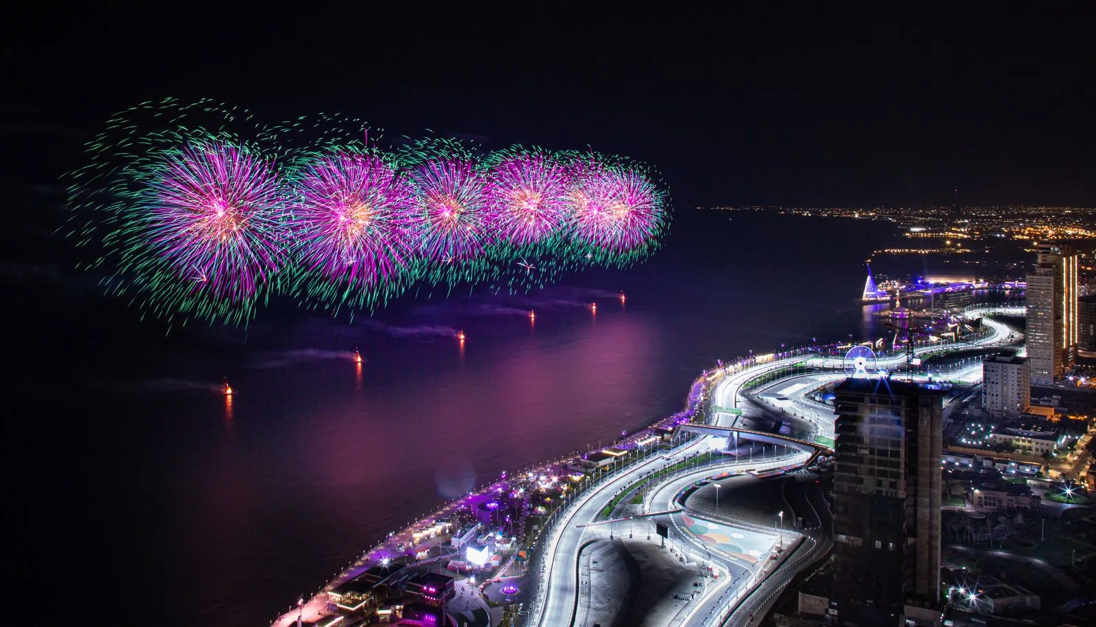Fireworks illuminating a waterfront cityscape during a Saudi festival celebration