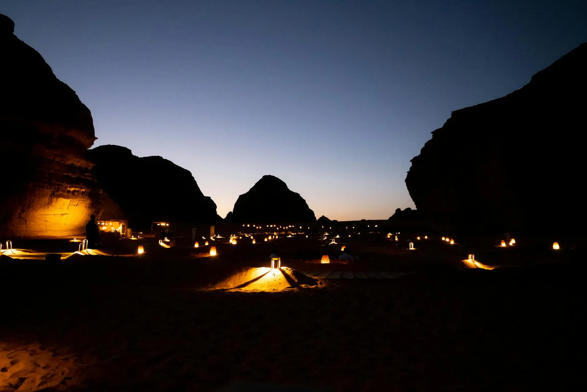 Hegra tombs carved into sandstone cliffs at sunset in AlUla