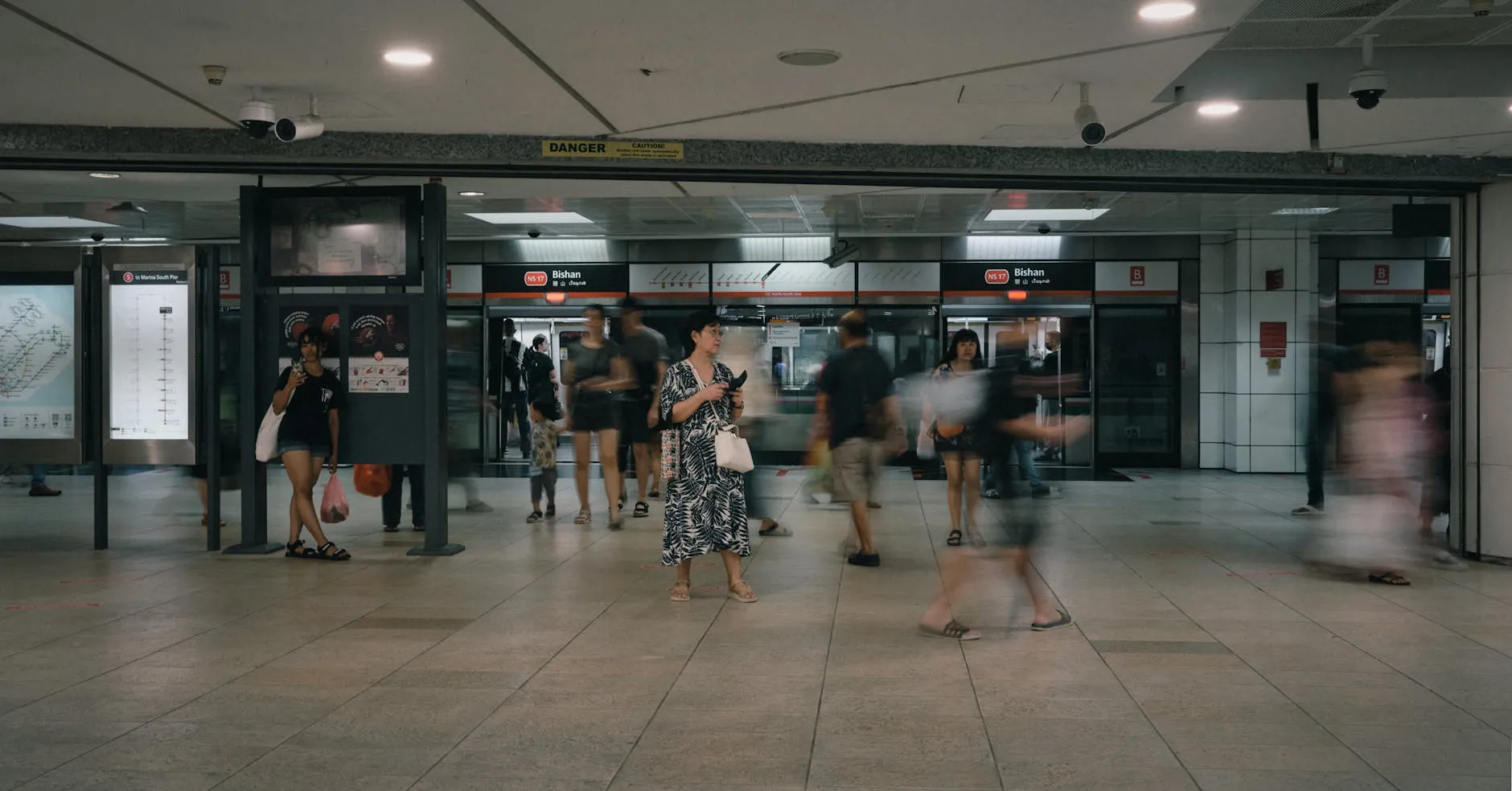 A crowded Bishan MRT station with commuters moving through the transit area.