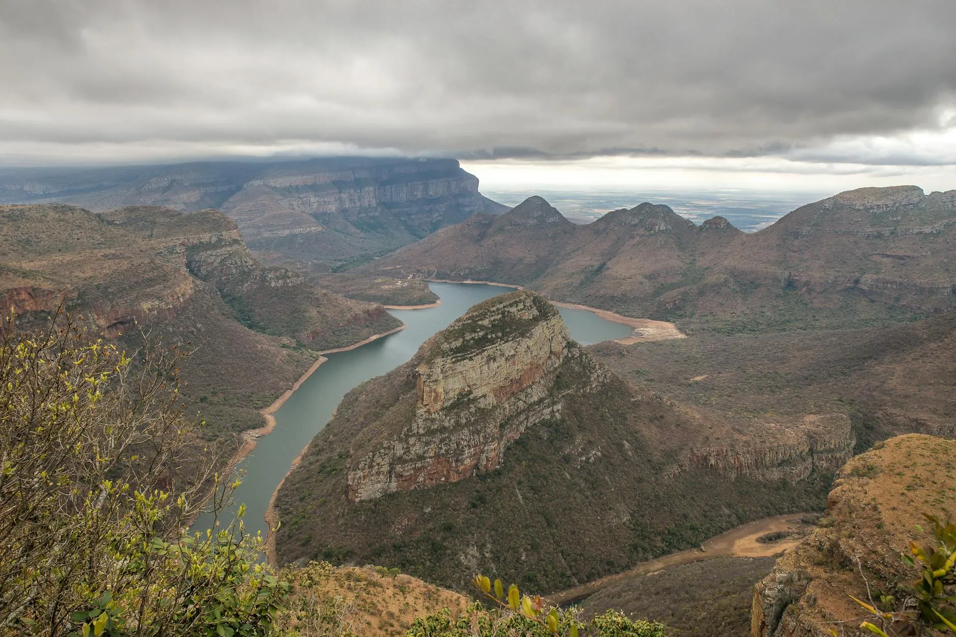 A breathtaking aerial view of Blyde River Canyon with rocky landscapes and cloudy sky.