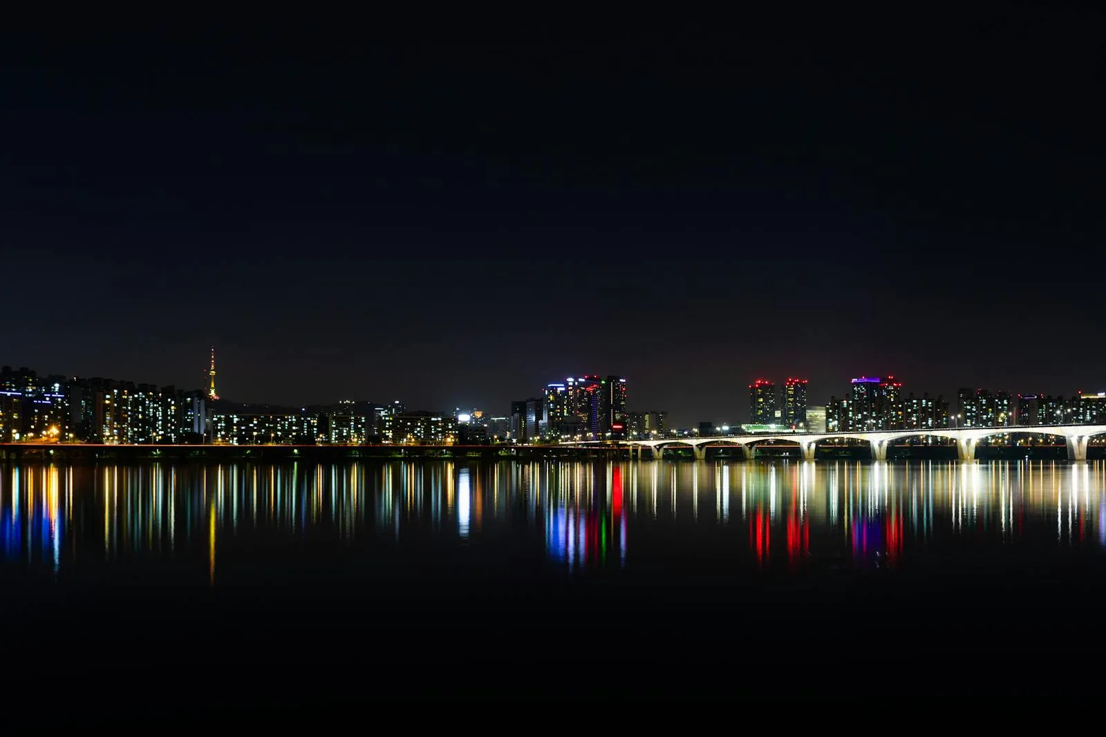 Stunning night view of Seoul's illuminated skyline reflected over the Han River.