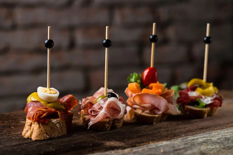Elaborate pintxos lined up on a bar counter in San Sebasti&aacute;n