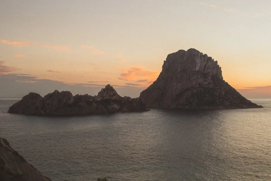 Cala d Hort beach with Es Vedra rock island at sunset