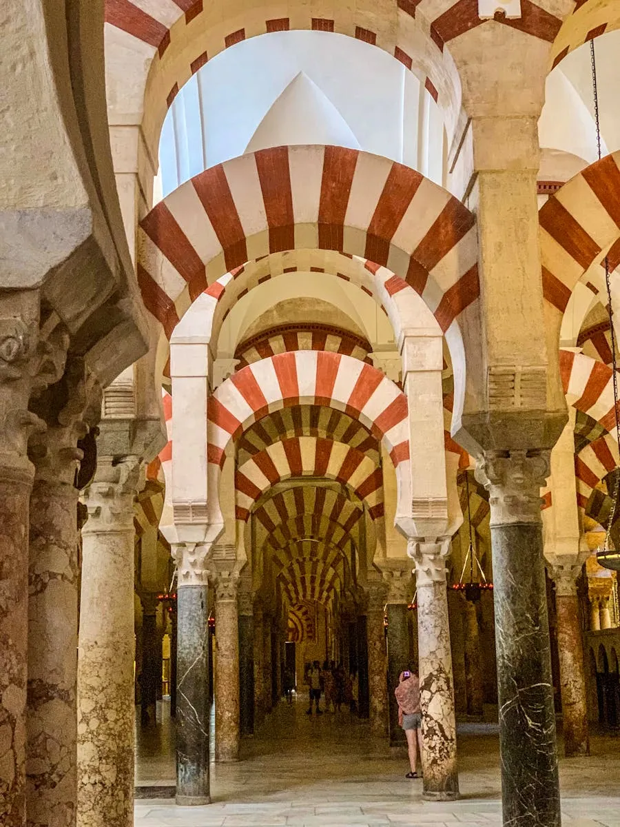 Red and white double arches stretching through the Mezquita in Cordoba