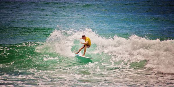 Dynamic aerial maneuver by surfer on beach waves