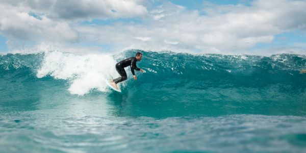 A surfer skillfully rides a large wave at Haleiwa Beach, Hawaii
