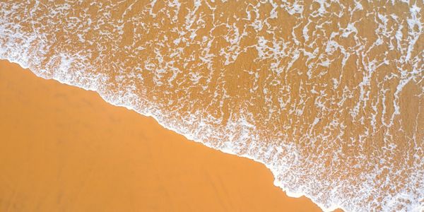 Warm-water reef break with surfers on southern coast