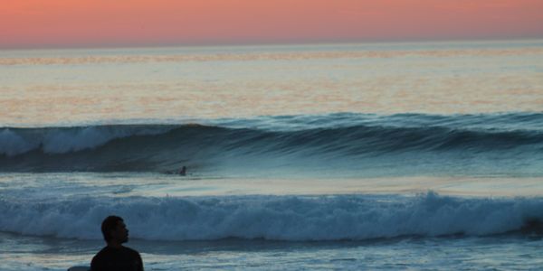 Surfer at the shoreline in Ericeira, Portugal
