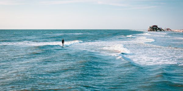Surfer catching waves during sunrise at Sunshine Coast, Australia