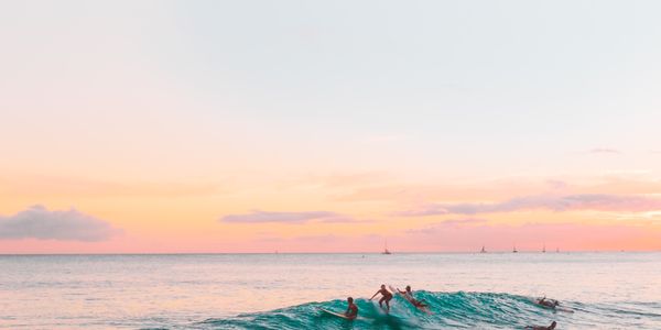 Surfers riding waves at sunset in Imsouane, Morocco