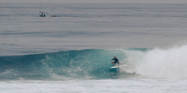 Surfer riding waves at Bali's stunning coastline