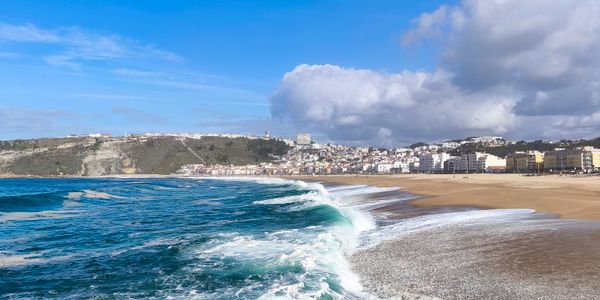 Breathtaking view of Nazaré beach with waves crashing against rocks, Portugal