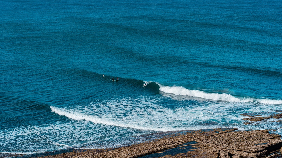 Reef break at Ribeira d'Ilhas, Ericeira — powerful waves breaking over a rocky reef shelf