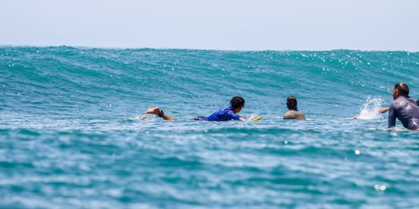 Surfers paddling on a sunny day in Sayulita, Mexico