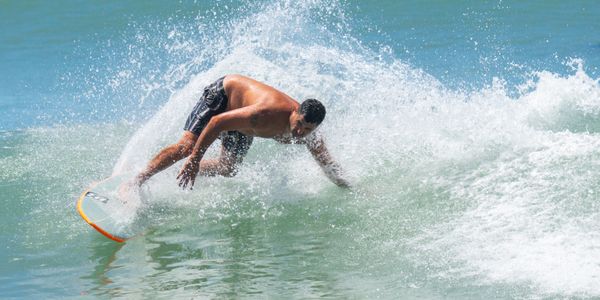 Surfer riding waves at Bali's stunning coastline