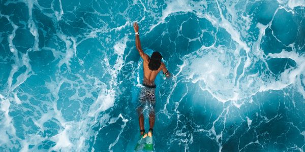 Aerial view of surfers catching waves in tropical waters