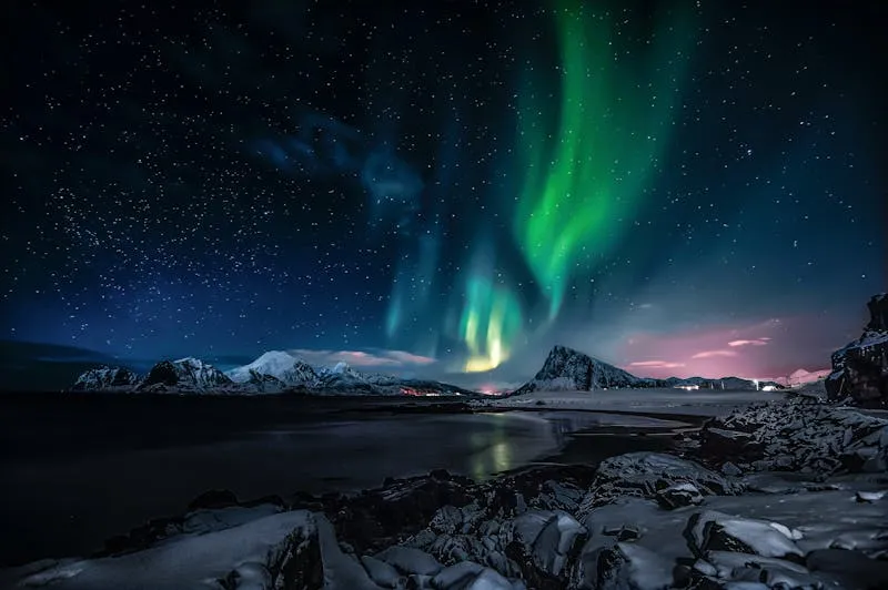 Aurora borealis over snowy mountains in Abisko National Park