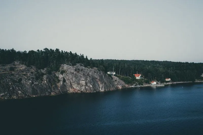 Red wooden boathouses on a rocky island in the Stockholm Archipelago