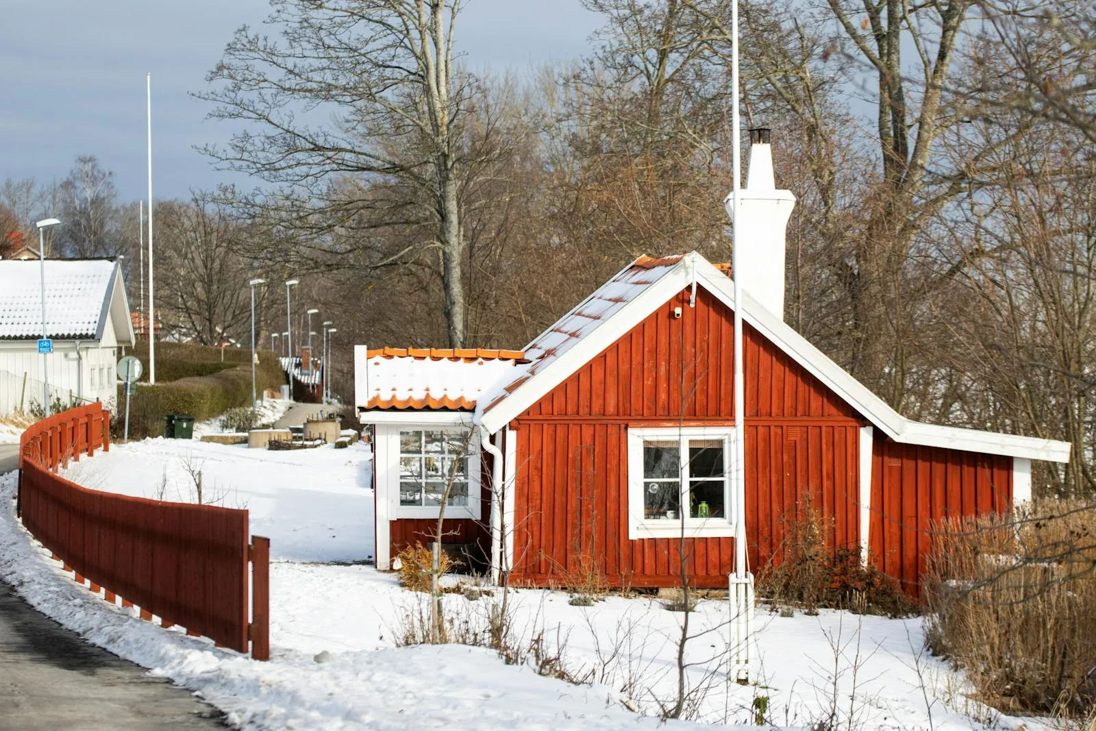 Snow-covered Swedish village with warm lights glowing in winter dusk
