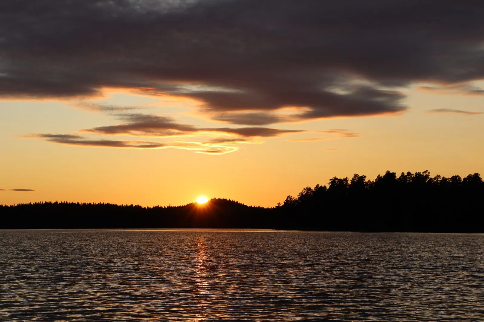 Tranquil sunset over a Swedish lake with stunning colours and peaceful water reflections