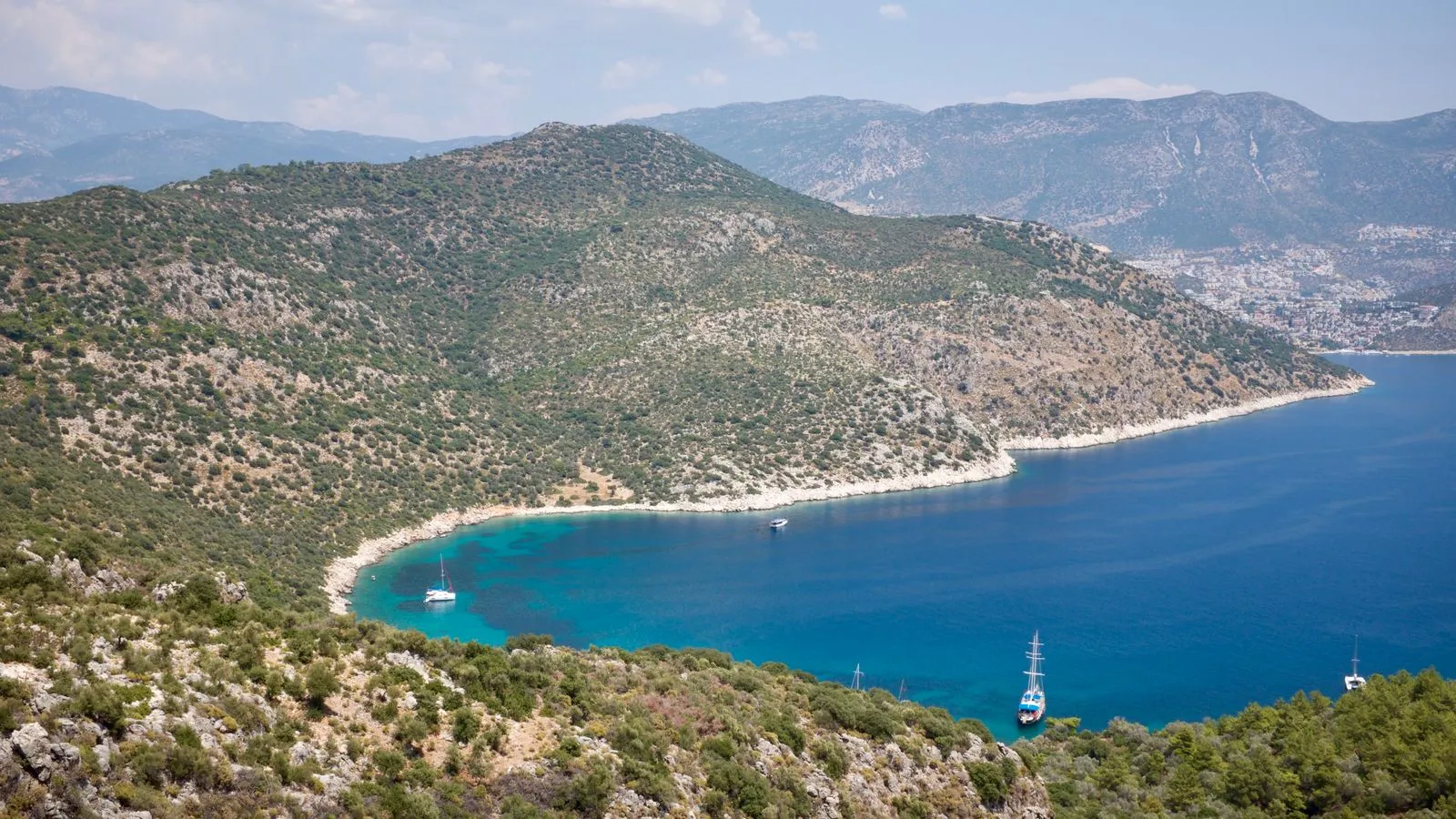Backpackers overlooking a turquoise bay on the Aegean coast