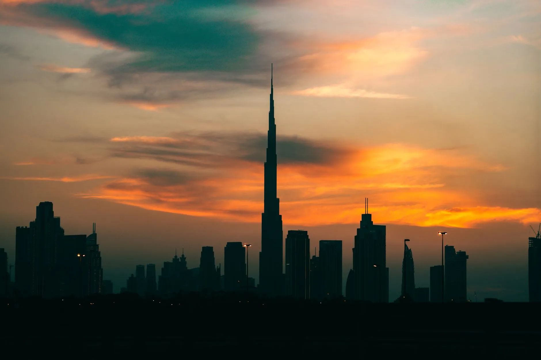 Burj Khalifa tower piercing through low clouds at sunrise