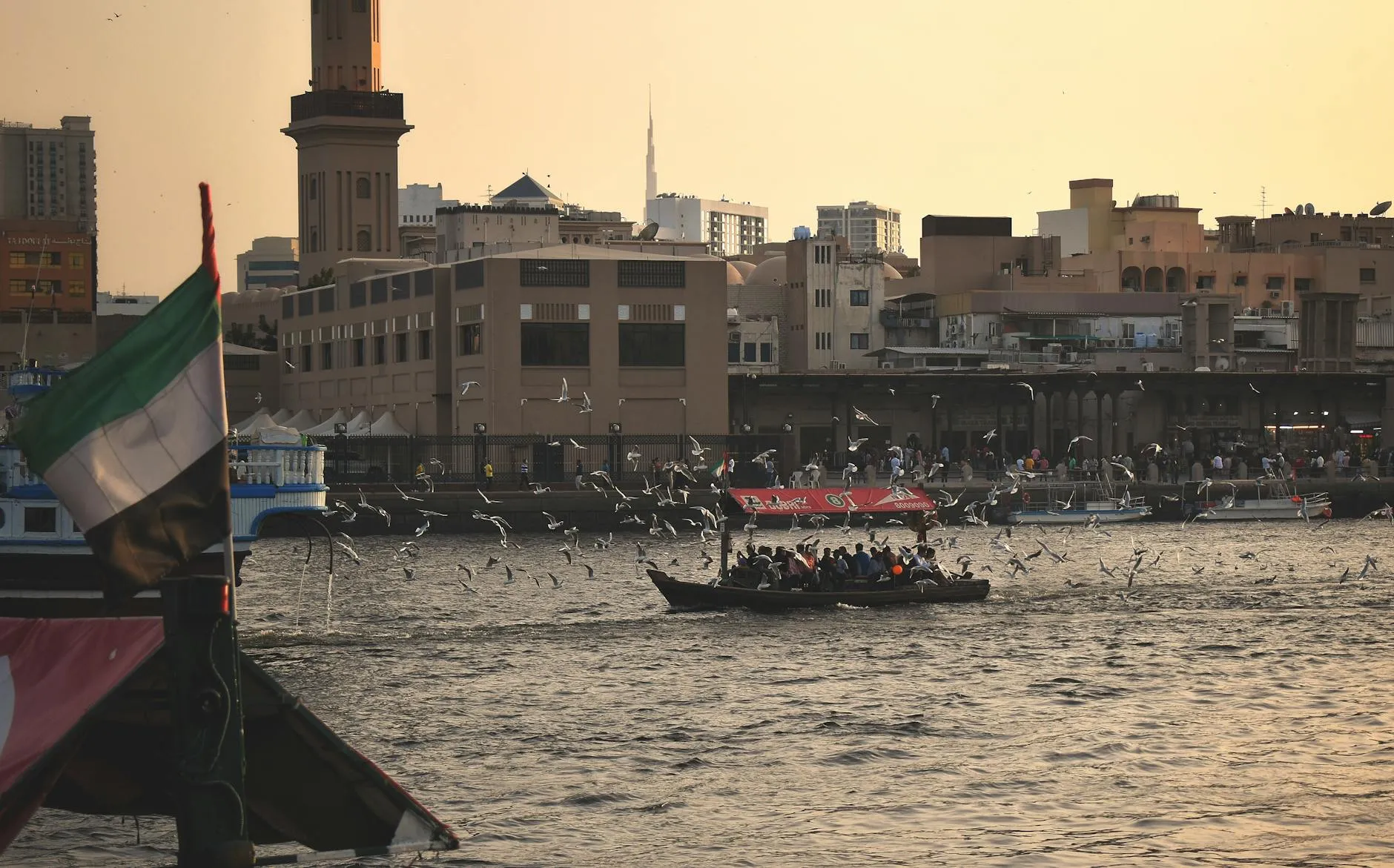 Traditional abra boat crossing Dubai Creek at sunset
