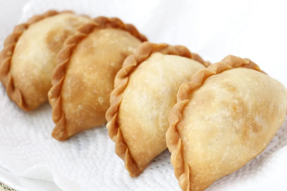 Golden Cornish pasty with crimped edge on a plate