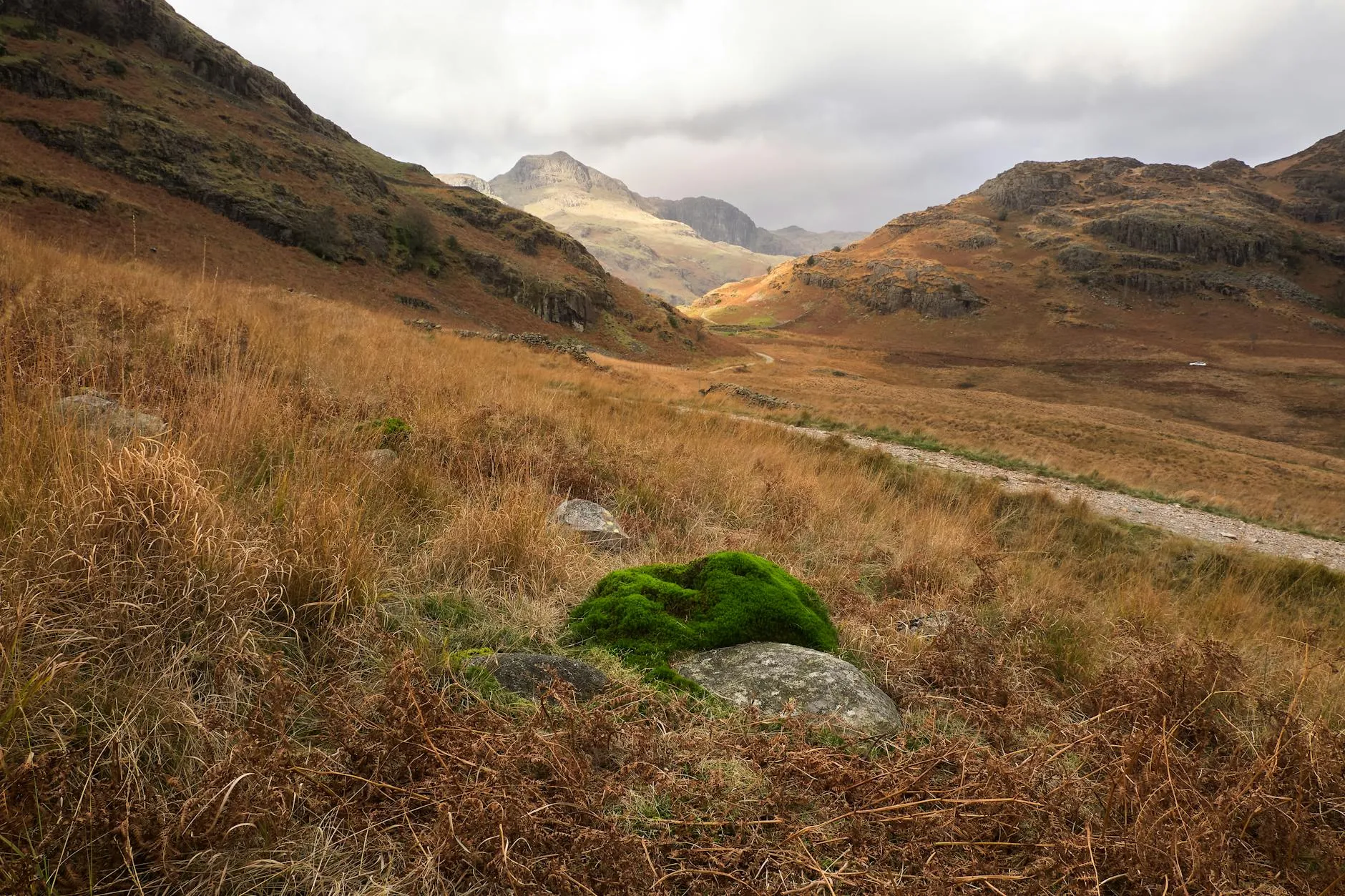 Walker on a mountain ridge path in the Lake District with dramatic valley views
