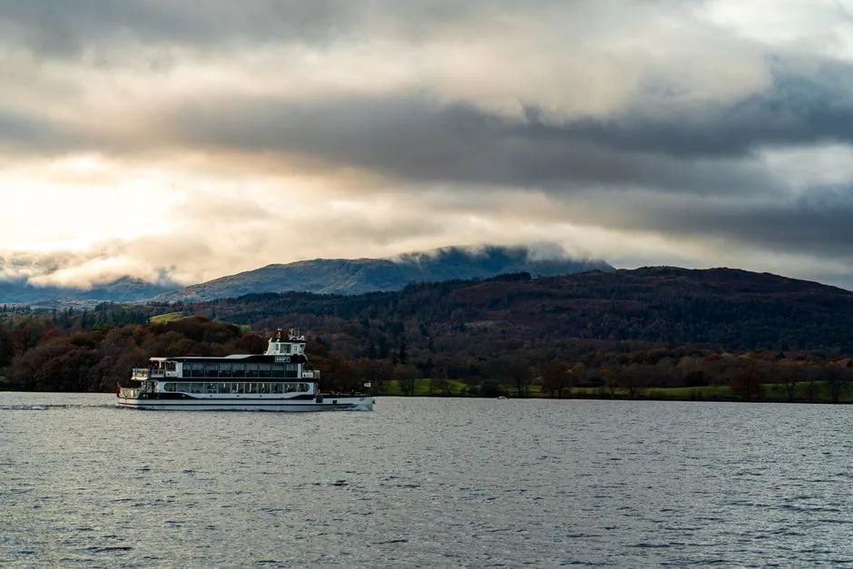 Windermere lake surrounded by green fells in morning mist
