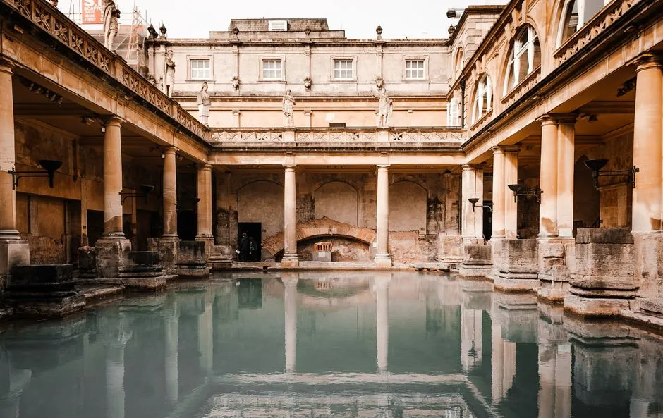 Roman Baths with steaming green water and Bath Abbey behind