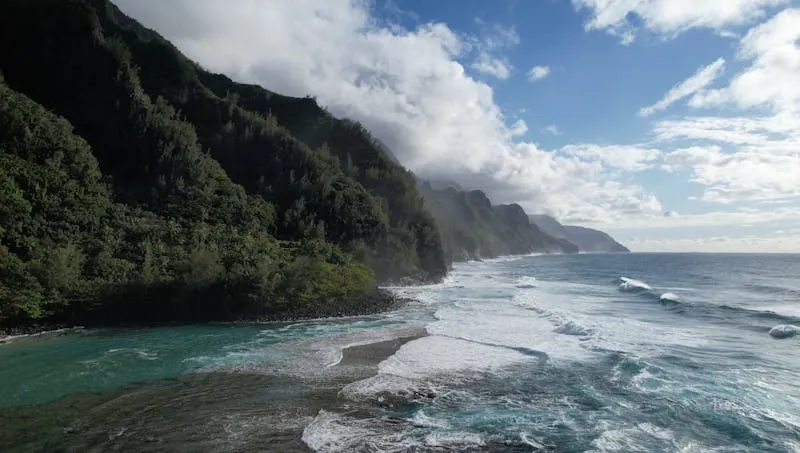 Na Pali Coast cliffs meeting turquoise ocean in Kauai Hawaii