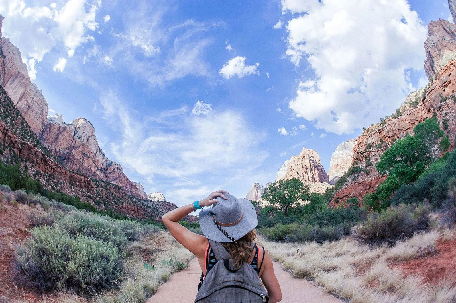 Hiker on a dramatic trail overlooking Zion Canyon