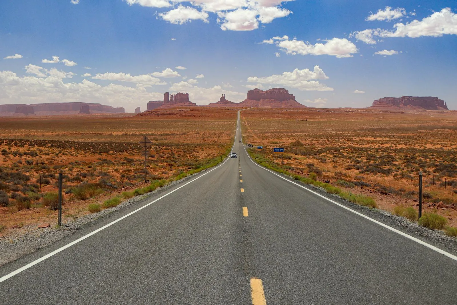 Open highway stretching through the American desert toward distant mesas