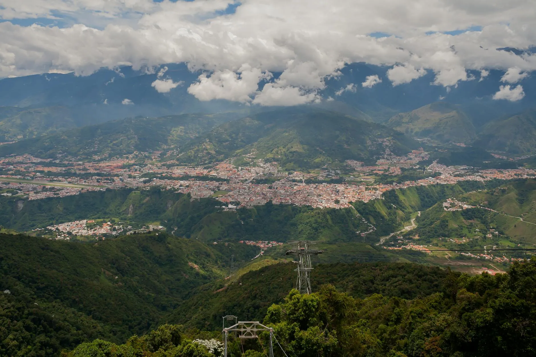 Stunning landscape of Mérida, Venezuela with lush green hills and cloudy mountaintops.