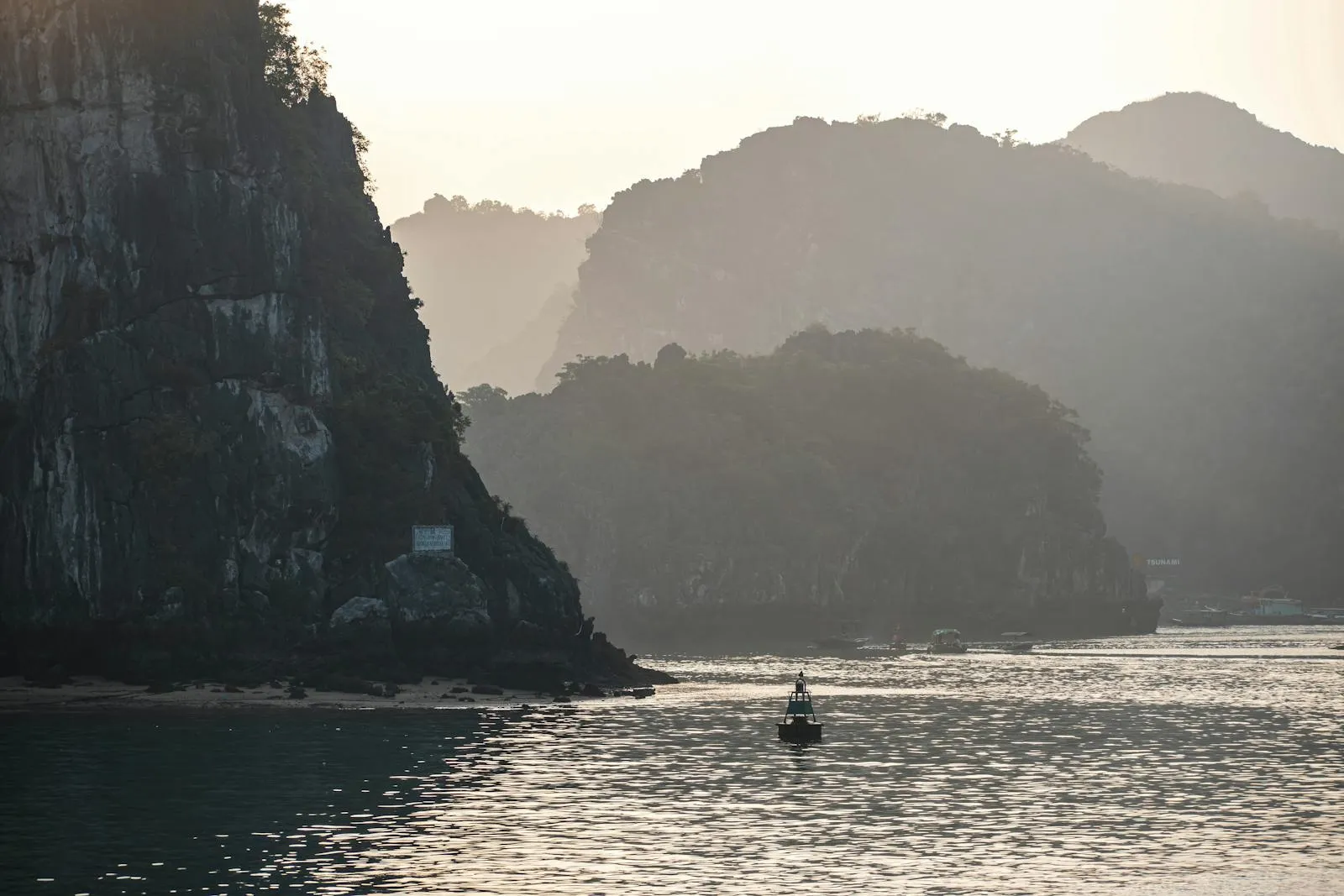 Peaceful view of Ha Long Bay with limestone cliffs in the evening light.