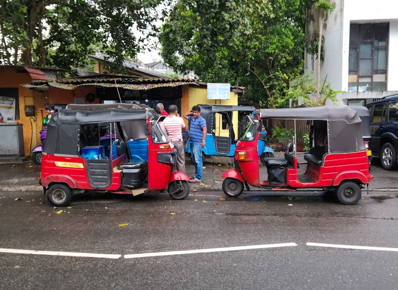 Colorful red tuk-tuks parked on a Sri Lankan roadside